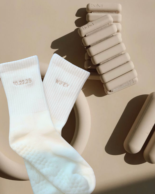 a pair of white grip socks with the words "wifey" and a wedding date embroidered on them next to bala bands