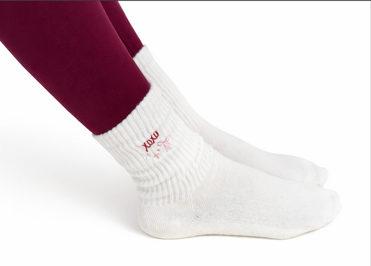 White socks with 'XOXO' text worn by a person on a white background