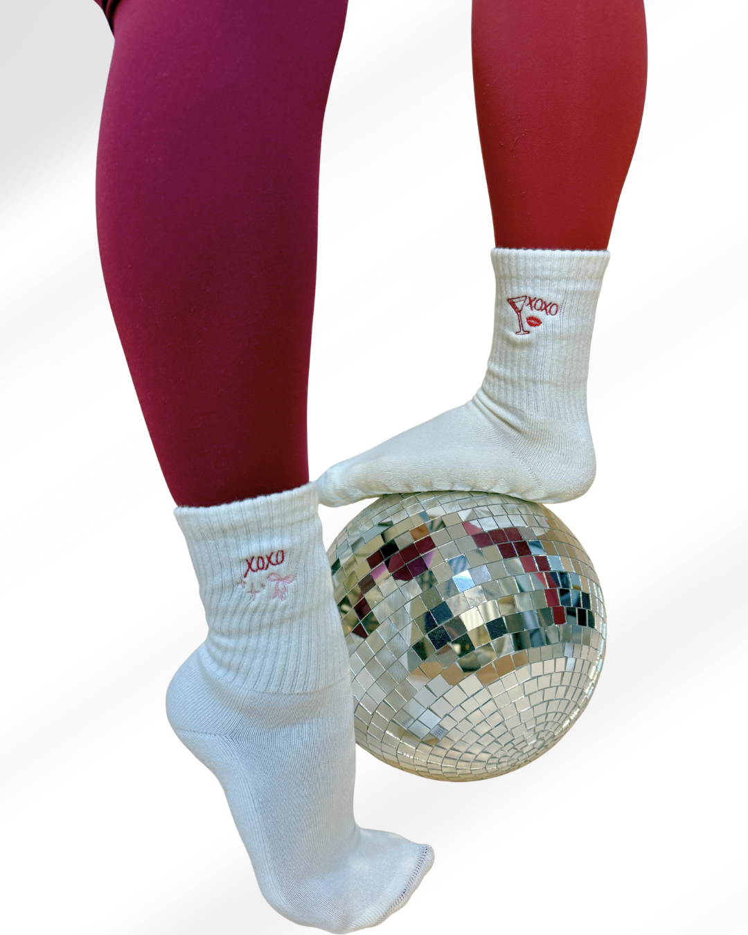 Two pairs of Valentine's day themed grip socks on top of a disco ball